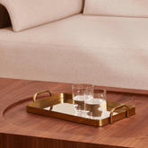 bandeja dourado com vidro espelho e copos de whisky no centro da sala de estar